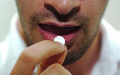 Man takes a pill for stimulation